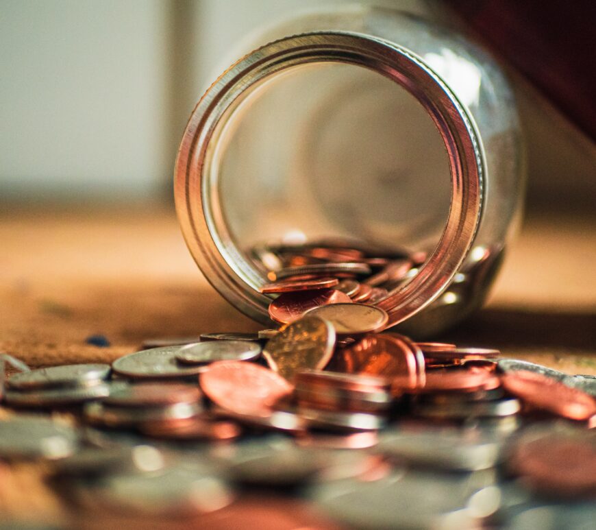 Jar with coins flowing out of it